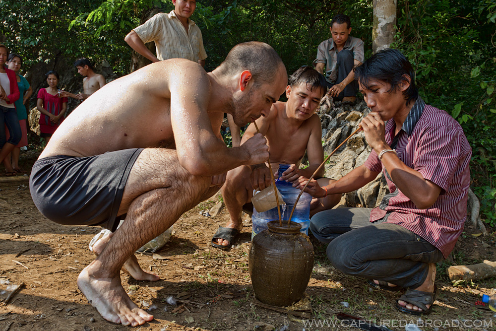 Drinking Laohoi rice wine with locals at a cool spring in Bo Houay Namgen on the "Thakhek loop"