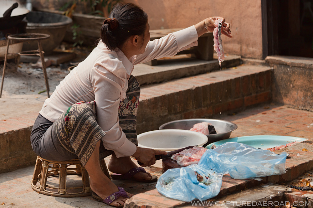 Cleaning/gutting fish in the street in Luang Prabang
