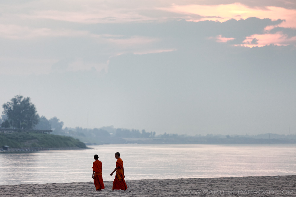 Monks walk on Don Chan bank of the Mekong river in Vientiane