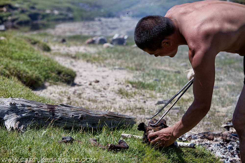 Man plays with a goats head after cooking